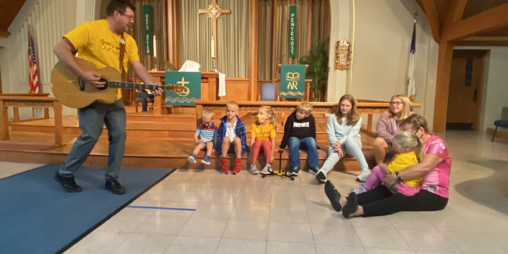 Pastor Tim plays guitar during Children's Sermon at St. Mark's Lutheran Church.